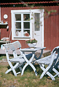 Garden table and chairs on the grass in front of the house