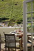 Tisch und Stühle auf der Terrasse eines Strandhauses in Port Issac, Cornwall