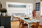 Wooden chairs at table with vintage signs in Shoreham by Sea, West Sussex, UK