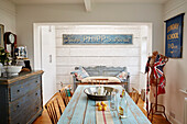 Metal bowl on table with bench seat and vintage signs in Shoreham by Sea kitchen West Sussex, UK