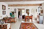 Wooden furniture in open plan living room with white painted floorboards Bridport home, Dorset, UK