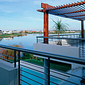 Blick vom Balkon auf die Pool-See-Terrassen und den modernen Außenbereich