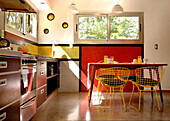 Der Fußboden der Küche ist aus geglättetem Beton, und an den Wänden, die mit perfekt geometrischen Fliesen bedeckt sind, und an den kleinen runden gelben Fenstern kommt die Farbe wieder zum Vorschein - ein Merkmal, das den Designer dieses erstaunlichen Hauses charakterisiert