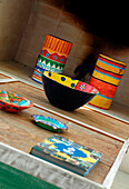 Bunte Schalen auf gestrichenem Holz-Couchtisch zusammengesetzt aus 4 einzelnen Tischen