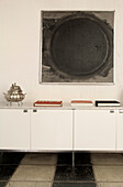 Sideboard with books under artwork