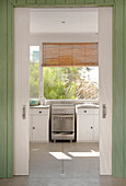 Kitchen with green granite worktop and wood wall hiding sliding doors