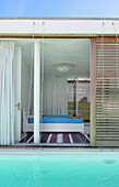 Lapacho wood sliding shutters of bedroom open directly to swimming pool