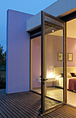 View through windows of cube house with decking to bedroom