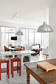 Ess- und Wohnzimmer von der Küche aus: Weiß durchbrochen von Leuchtkörpern