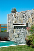 Dry stone wall and pool set on grass lawn
