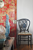 Orientalisch lackierte Truhe und geschnitzte Stuhllehne mit Figurine