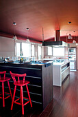 Küche mit roter Decke und Barhockern am Tresen