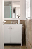 Weiß gestrichener Schrank unter dem Badezimmerspiegel