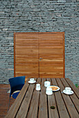 Modern dining exterior with unfinished stone wall and wooden double doors