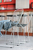 Metal frame chairs with denim jacket on concrete flooring