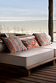 Gemusterte Kissen auf einem Sofa auf der Veranda eines Strandhauses