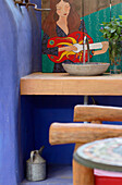 Oak table and bench seats with cactus at doorway to blue painted veranda