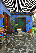 Private porch with wood roof and concrete floor with encrusted slices of trunk