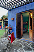 Deck chair on private porch with shuttered doors opening to child's bedroom