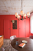 Runder Tisch in rotem Wohnzimmer mit Deckenleuchte