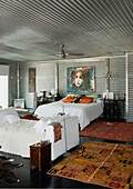 Galvanized metal bedroom with Chinese furniture and a rabbit fur covered chaise longue