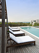 Sun-loungers on poolside decking