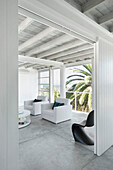 White living room with large windows and beamed ceiling