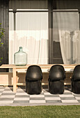 Louis Panton chairs at wooden table with water container and curtained windows