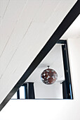 Black and white panelled staircase with view through doorway to light fitting