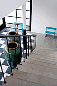 Concrete staircase with oversized pottery urns on checked floor