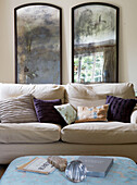 Cream sofa with purple scatter cushions in front of double frieze in 17th Century Oxfordshire living room