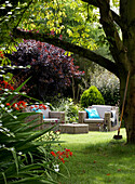 Sitzgelegenheiten im Freien unter einem Baum im Sommergarten