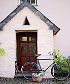 Bicycle parked at porch with pitched roof