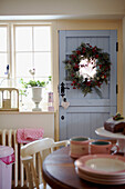 Sonnenbeschienene Küche mit Weihnachtsgirlande an blau gestrichener Hintertür