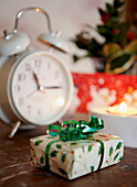 Wrapped Christmas present and white alarm clock