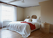White bed cover in beamed sunlit bedroom