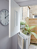 Wall mounted clock at open back door