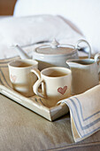 Cream cups and teapot with milkjug on tray