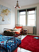 Metal framed beds with contrasting duvets and rug in Edwardian terraced house bedroom