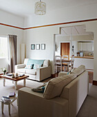 White sofas with turquoise cushions and blanket in living room of Wairarapa home North Island New Zealand