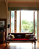 Nicht zusammenpassende Kissen auf dem Sofa im sonnenbeschienenen Eingangsbereich eines Hauses in Masterton, Neuseeland