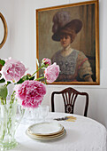 Cut flowers and tableware with artwork in dining room of 18th Century Georgian terrace Hampstead, London