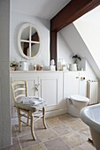Cream bathroom with built in cupboards ad beamed ceiling