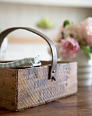 Wooden crate with leather handle on kitchen table