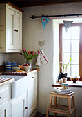 Sonnendurchflutetes Fenster und Butler-Spüle in einer Küche in einem Cottage in Devon