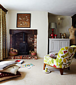 Wood burning stove in Devon cottage with floral print chair