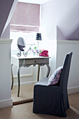 Slip covered chair at dressing table in dormer window