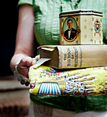 Frau hält Kissen mit Dose und Buch über Handarbeiten