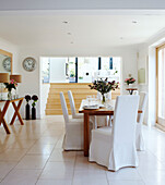 Open plan dining room with white slip covered chairs