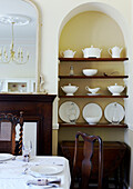 Recessed arch with display of chinaware in dining room